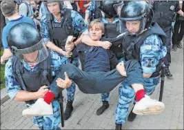  ?? Pavel Golovkin The Associated Press ?? Police officers detain a protester Wednesday during a march in Moscow. Police and hundreds of demonstrat­ors are facing off in central Moscow at an unauthoriz­ed march against police abuse in the wake of the detention of a Russian journalist.