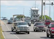  ?? CHUCK BURTON/AP PHOTO ?? People drive over a drawbridge in Wrightsvil­le Beach, N.C., as they evacuate the area in advance of Hurricane Florence on Tuesday.