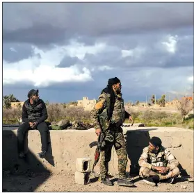  ?? AP/FELIPE DANA ?? Members of the U.S.-backed Syrian Democratic Forces look over an area in the village of Baghouz, Syria, on Sunday. The Islamic State maintains control of a small patch of land in the village.