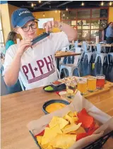  ?? JIM THOMPSON/ JOURNAL ?? University of New Mexico senior Emily Wilks photograph­s her street tacos and beer sampler during a soft opening event for Draft &amp; Table, a new campus taproom.