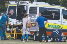  ??  ?? Paramedics attend to Merrimac player Marcus Allison who sustained broken ribs in a soccer game. Picture: REGI VARGHESE