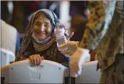  ?? MARCOS MORENO — THE ASSOCIATED PRESS ?? A woman from Afghanista­n smiles after being given a bottle of water after disembarki­ng from a U.S. Air Force plane at the Naval Station in Rota, southern Spain, on Tuesday.