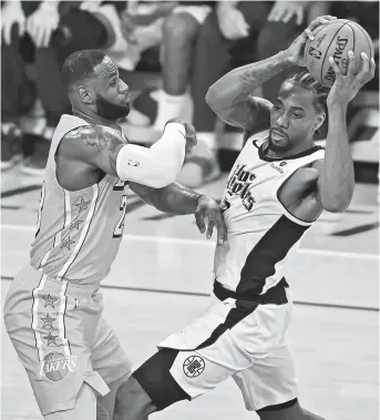  ??  ?? Los Angeles Lakers forward LeBron James guards Los Angeles Clippers forward Kawhi Leonard during their NBA clash at Staples Center on Wednesday. — AFP