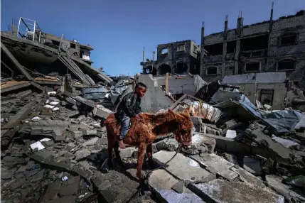  ?? AFP PHOTO ?? SAD RIDE
A Palestinia­n boy rides a donkey on the rubble of destroyed houses in a refugee camp in the Gaza Strip’s southernmo­st city of Rafah on Thursday, March 21, 2024.