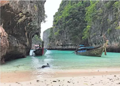  ?? AP PHOTOS ?? Long-tail boats sit near a small beach on Ko Phi Phi Leh, an island off the southweste­rn coast of Thailand. The smaller of the Phi Phi Islands is a tourist hotspot for its beautiful water, party atmosphere and famed Maya Bay, where the movie “The...