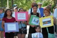  ?? MARIAN DENNIS – DIGITAL FIRST MEDIA ?? A family stands together outside the Montgomery County Courthouse Saturday during the Families Belong Together rally. The rally was one of many held Saturday all over the country.