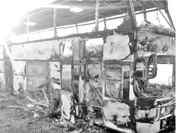  ?? — AFP photo ?? A charred bus on a road in the region around the city of Aktobe.