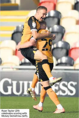  ??  ?? Ryan Taylor (29) celebrates scoring with Mickey Demetriou (left).