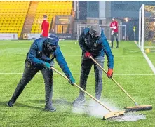  ??  ?? Ground staff work on the surface at the Tony Macaroni Arena before last night’s late call-off.