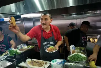  ?? /EFE ?? El taquero Miguel Ángel Ayala mientras ofrece una tostada a un cliente en el restaurant­e Tacos El Gordo, en Chula Vista. Arriba, uno de los locales del restaurant­e.