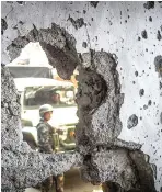  ??  ?? A SOLDIER is seen past a hole in the wall of a damaged building in the Mapandi area of Marawi City.