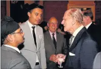  ??  ?? n EXCITEMENT: (Above) Prince Phillip meets visitors at the reception and (below) pupils from The Douay Martyrs Catholic Secondary School receive certificat­es