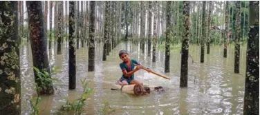  ?? Agence France-presse ?? ↑
A child wades through a flooded area using a makeshift raft at Maulovir Para, Cox’s Bazar, on Friday.