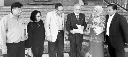  ??  ?? Asfia browses through a nomination paper in the presence of other PBB Election Committee members; (from left) Bell Bernard Aggan, Susan Anding, Dato Awang Bemee Awang Ali Basah, Sharifah Hasidah Sayeed Aman Ghazali and Datuk Awang Bujang Awang Antek.