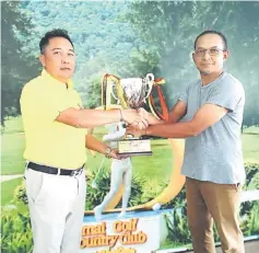  ??  ?? Roslan (left) receives the champion’s trophy from Wan Saperi.