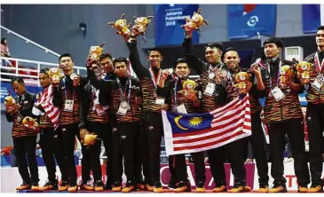  ??  ?? Second best: Malaysia’s sepaktakra­w team celebrate on the podium after winning the silver medal at the JSC Ranau Hall in Palembang, Indonesia, yesterday. — Reuters