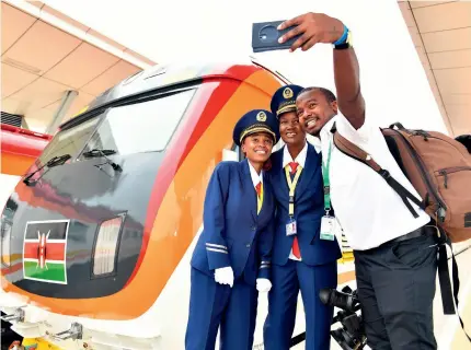  ?? ?? A Kenyan journalist (right) takes selfies with train drivers during the launch day of the MombasaNai­robi Standard Gauge Railway in Mombasa, Kenya, on 31 May 2017