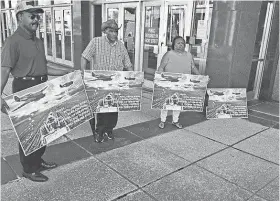  ?? TOM CHARLIER ?? Representa­tives of the Black Farmers and Agricultur­alists Associatio­n hold up signs before a news conference Tuesday.