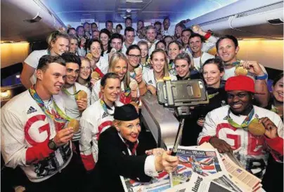  ??  ?? ALL SMILE: Gold medallists of Team GB pose for a selfie with a member of British Airways cabin crew