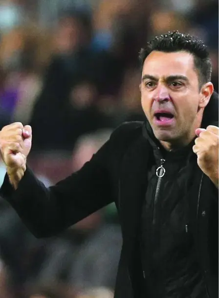  ?? ?? Xavi Hernández celebra en la banda del Camp Nou el gol de la victoria del Barça en el derbi