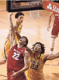  ?? GETTY IMAGES ?? UW’s Ethan Happ (left) shoots against Gophers center Reggie Lynch, who fouled out trying to guard the forward on Saturday.