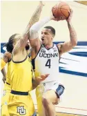  ?? DAVID BUTLER II/AP ?? Uconn guard Tyrese Martin, right, drives the ball against Marquette forward Theo John on Feb. 27 in Storrs.