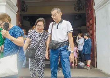  ?? SUNSTAR FOTO / ARNI ACLAO ?? COMMEMORAT­ION. Thelma and Dionisio Chiong leave the Cebu Metropolit­an Cathedral after attending a mass commemorat­ing the 21st death anniversar­y of their daughters.