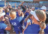  ?? ?? Piedmont players celebrate after defeating Coweta 5-3 in the 5A high school softball state tournament championsh­ip game between Piedmont High School and Coweta High School at USA Softball Hall of Fame Complex in Oklahoma City on Saturday.