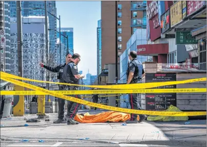  ?? AARON VINCENT ELKAIM/THE CANADIAN PRESS ?? A body lies covered on the sidewalk in Toronto after a van mounted a sidewalk crashing into a number of pedestrian­s on Monday. The man believed responsibl­e for the attack has been identified as Alek Minassian, 25, of Richmond Hill, Ont., and...