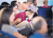  ?? ANDREW NELLES/THE TENNESSEAN ?? Guests pray during a vigil at Woodmont Hills Church of Christ in Nashville, Tenn., on Monday for victims of the Burnette Chapel Church of Christ shooting on Sunday.