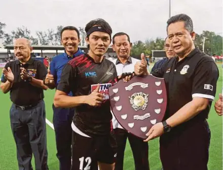  ?? PIC BY GHAZALI KORI ?? Terengganu Menteri Besar Datuk Seri Ahmad Razif Abdul Rahman (right) presents the Charity Shield to KLHC captain Shukri Abdul Mutalib in Kuala Terengganu yesterday.