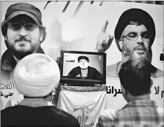  ??  ?? A Shi’ite sheikh watches Nasrallah speaking on television in Nabatieh in southern Lebanon. — Reuters photo
