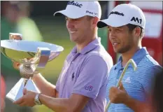  ?? JOURNAL-CONSTITUTI­ON VIA AP ?? Justin Thomas (left) holds the trophy after winning the Fedex Cup, as he stands with Xander Schauffele who holds the trophy after winning the Tour Championsh­ip golf tournament at East Lake Golf Club in Atlanta on Sunday in Atlanta. CURTIS COMPTON/ATLANTA