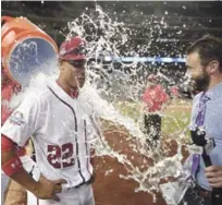  ??  ?? El novel Juan Soto es roceado con un cubo de agua en su primer entrevista luego de batear su primer jonrón.