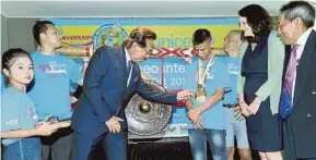  ?? PIC BY IZHARI ARIFFIN ?? Sabah Chief Minister Datuk Seri Musa Aman looking at the medals won by Zulkarnain Mohd Riduan after launching the marathon in Kota Kinabalu yesterday.