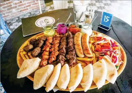  ?? YOUSOS APDOULRASH­IM ?? The mixed meat platter consists of sausages, beef, chicken, meatballs, homemade fries, side salad and pita bread.