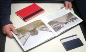  ??  ?? Book binder Alistair MacLellan with some of his work, including a journal, a notebook and a client’s photograph­y book.