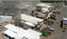  ??  ?? Fire department personnel respond to two trailer homes in a trailer park that caught fire on Friday afternoon in El Centro. PHOTO COURTESY OF LUIS BUGARIN