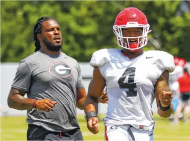  ?? GEORGIA PHOTO/TONY WALSH ?? Georgia student assistant Jarvis Jones, a two-time All-American for the Bulldogs during the 2011-12 seasons, helps freshman outside linebacker Nolan Smith (4) during a drill earlier this month.