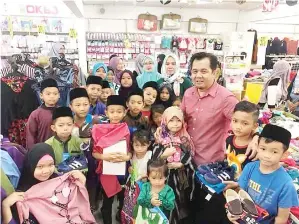  ??  ?? JAMAWI (tiga dari kanan) bersama anak yatim, golongan asnaf dan kurang upaya yang diraikan dalam program itu.