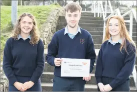  ?? (Pic: Ita West) ?? Sarah Blade and Olivia Donohue, both representi­ng the Wellbeing Committee at Scoil Pól Kilfinane, presenting Liam Fitzgerald with his certificat­e for achieving a running distance of over 92km over the 10-day Wellbeing Week challenge.