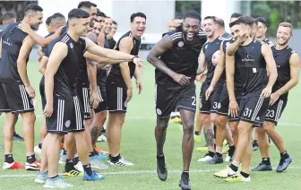  ??  ?? Emmanuel Adebayor (centro), delantero de Olimpia, en su primer día de práctica en la Villa de Fernando de la Mora, donde fue recibido de muy buena manera por sus demás compañeros.