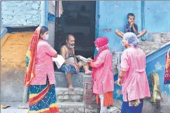  ?? RAJ K RAJ/HT ?? Asha workers speak to a resident during a door-to-door survey at JJ colony in Patparganj. ■