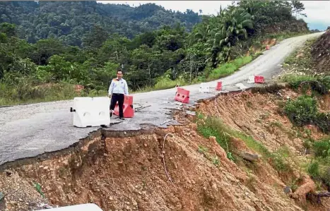  ??  ?? Dicing with danger: Abun visiting the site of the eroding hillslope along the Belaga-Menjawah road in northern Sarawak.