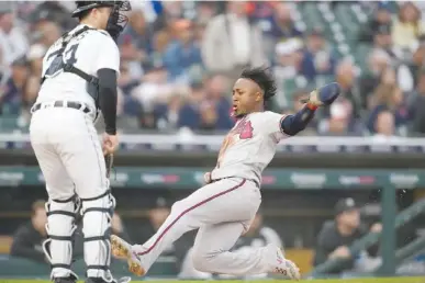  ?? AP PHOTO/CARLOS OSORIO ?? Atlanta Braves' Ozzie Albies scores from third Monday during the sixth inning of a baseball game against the Detroit Tigers in Detroit.