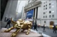  ?? THE ASSOCIATED PRESS ?? A miniature reproducti­on of Arturo Di Modica’s “Charging Bull” sculpture sits on display at a street vendor’s table outside the New York Stock Exchange in lower Manhattan.
