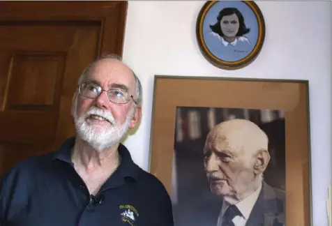  ?? Philip Marcelo/Associated Press photos ?? Ryan Cooper stands next to a photo of Otto Frank, the father of the famed Holocaust victim and diarist Anne Frank, on June 7 at his home in Yarmouth, Mass. Above the photo is a painting of Anne Frank by Mr. Cooper. He donated a trove of letters and mementos he received from Otto Frank to the U.S. Holocaust Memorial Museum.