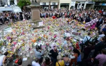  ??  ?? In Manchester kwamen gisteren tal van mensen op straat om met een minuut stilte alle slachtoffe­rs te herdenken. Nadien begon een vrouw in de menigte het nummer
Don’t Look Back in Anger van Oasis te zingen, waarna velen invielen. Een indrukwekk­end...