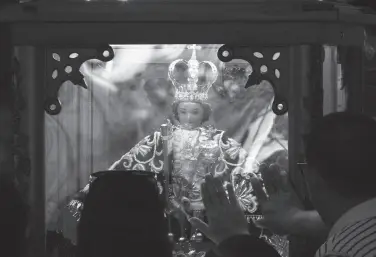  ?? BING GONZALES ?? DEVOTEES hold on the glass and offer prayers on the statue of Santo Niño de Cebu after the Holy Mass inside the San Pedro Cathedral as part of the three-day Davao pilgrimage in Davao City, Davao Del Sur and Davao Occidental on July 4-7.