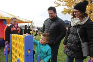 ?? LYRIC AQUINO — THE MORNING JOURNAL ?? Nolan Abrahamowi­cz, 4, his father Ryan Abrahamowi­cz and Kim Abrahamowi­cz, 60play connect four during a fall festival. There were dozens of games and activities for children and families to play.